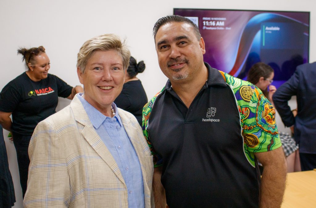 Megan and Brendan stand smiling at the camera